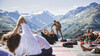Yoga in St. Anton am Arlberg Group of people doing yoga on a wooden platform with mountain scenery in the background