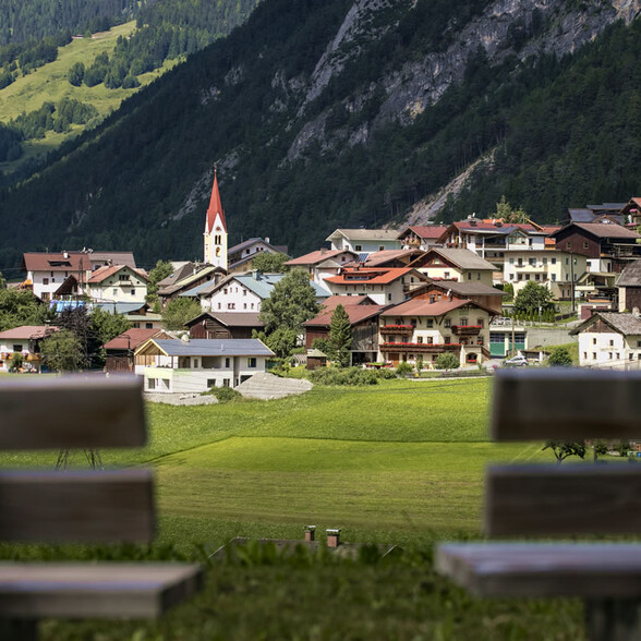 Das Bergdorf Schnann - samt Kirchturm - bei dynamischen Wetterbedingungen im Sommer