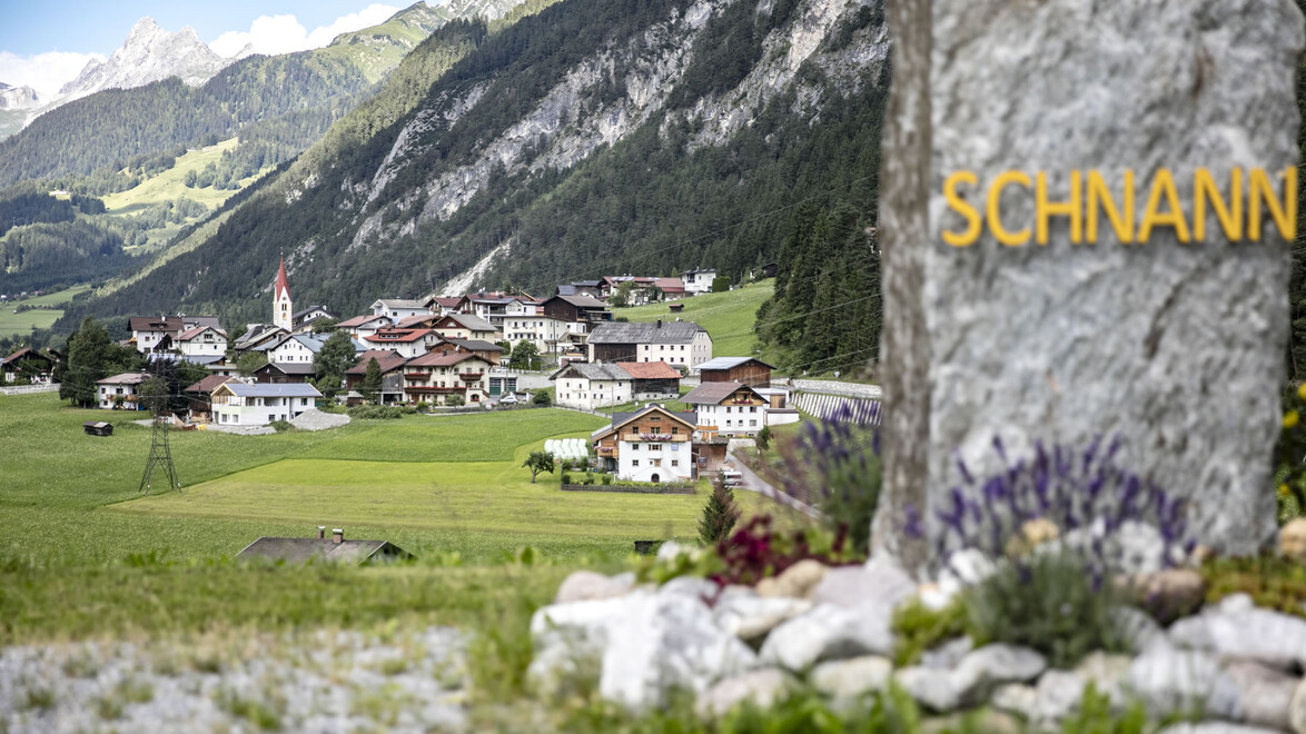 Schnann im Sommer mit Ortsname auf Stein geschrieben / Schnann in summer with place name written on stone /
