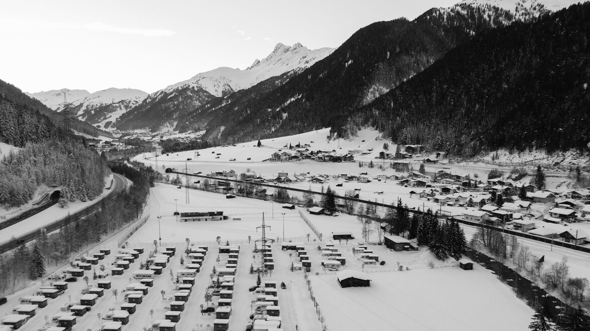Drohnenaufnahme von Pettneu über dem Campinggelände im Winter / Drone shot of Pettneu over the campsite in winter