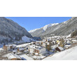 Dorf Flirsch in verschneiter Winterlandschaft mit Bergen im Hintergrund. / Flirsch village in snowy winter scenery with mountains in background.