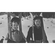 Zwei Mädchen mit Skiern im Schnee, traditionell gekleidet. / Two girls with skis in the snow, dressed traditionally.