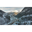 Strengen im verschneiten Tal mit Blick auf die leuchtende Bergspitze bei Sonnenuntergang. / Strengen in a snowy valley with glowing mountain peak at sunset.