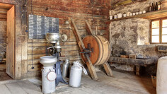  Traditional alpine kitchen with old milk churns, a centrifuge and a large wooden butter churn.