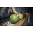 Nahaufnahme einer Hand, die eine grüne Kugel aufnimmt, mehrere Kugeln in Reihe / Close-up of a hand grabbing a green bowling ball, several balls in a row