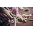 Hände beim Einbinden eines Kletterseils in den Gurt / Hands tying a climbing rope to the harness