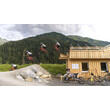 Sequenzaufnahme zeigt Sprung eines Bikers vor Hütten-Kulisse / Sequence image shows biker jump in front of hut backdrop