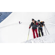 Zwei Skitourengeherinnen gehen nebeneinander eine steile Schneefläche hinauf, im Hintergrund weitere Tourengeher / Two ski tourers hike up a steep snowfield side by side, with others in the background