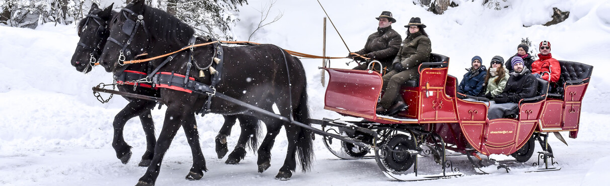 Romantic horse-drawn carriage ride through the snowy winter landscape in St. Anton am Arlberg.