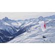 Paragleiter fliegt über eine verschneite Berglandschaft mit weitem Talblick / Paraglider flying over snowy mountain landscape with wide valley view