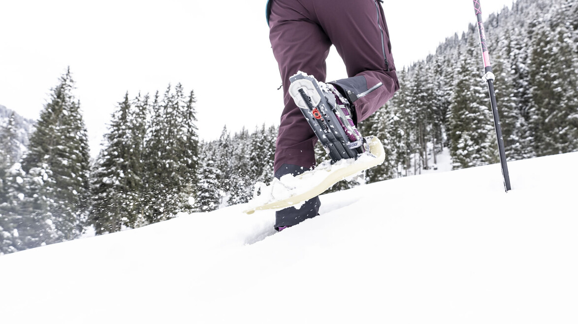 Nahaufnahme von Schneeschuhen beim Gehen durch den tiefen Schnee / Close-up of snowshoes walking through deep snow
