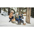 Drei Frauen sitzen lachend auf einem Baumstamm im verschneiten Winterwald / Three women sit laughing on a tree trunk in the snowy winter forest