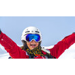 Freude beim Skifahren / Joy of skiing Lachende Skilehrerin mit erhobenen Armen vor verschneitem Hang / Smiling ski instructor with raised arms in front of snowy slope