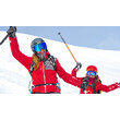 Skilehrerinnen im Schnee / Ski instructors in the snow Zwei Skilehrerinnen jubeln auf der Piste in roter Skikleidung / Two ski instructors cheer on the slope in red ski outfits