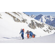Eine Gruppe Tourengeher:innen steigt im Gänsemarsch durch eine hochalpine Schneelandschaft / A group of ski mountaineers ascends in single file through high alpine snowy terrain