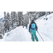 Personen wandern mit Tourenski auf einem verschneiten Weg durch einen Winterwald / People are ski touring on a snow-covered trail through a winter forest