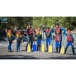 Gruppe mit Kindern und Erwachsenen in Neoprenanzügen mit Paddeln vor dem Rafting / Group of children and adults in wetsuits with paddles before rafting