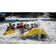 Raftinggruppe fährt durch starke Stromschnellen mit spritzendem Wasser / Rafting group going through strong rapids with splashing water