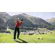 Ein Golfer schlägt am Abschlag mit Blick auf ein Bergdorf im Hintergrund. / A golfer tees off with a mountain village in the background.