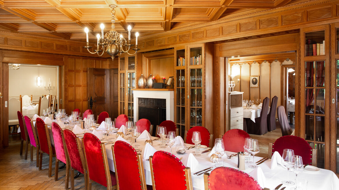 Eleganter Speiseraum mit langen Tischen und roten Stühlen / Elegant dining room with long tables and red chairs