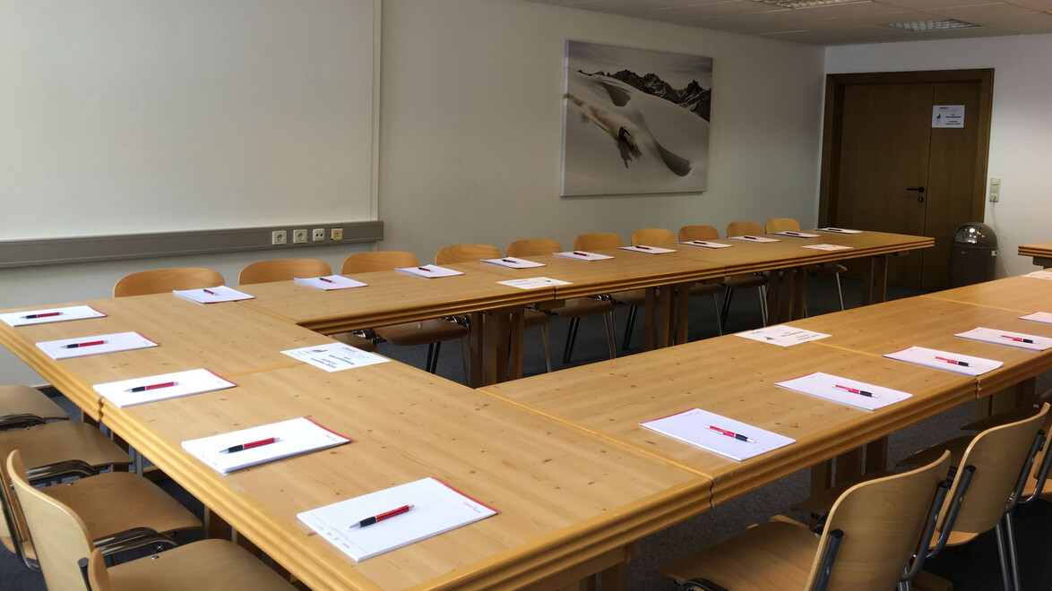 Besprechungsraum mit U-förmiger Tischanordnung und vorbereiteten Sitzplätzen / Meeting room with U-shaped table layout and prepared seats