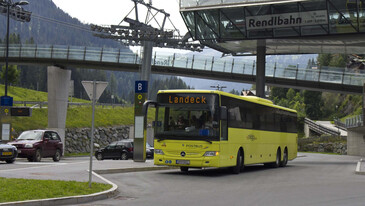 Yellow "Postbus" Bus departuring from Terminal West with the Rendlbahn in the background