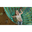 Ein Mädchen krabbelt lachend durch ein grünes Kletternetz an einem Spielplatz / A girl crawls smiling through a green climbing net at a playground