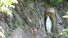 Die Lourdeskapelle mit Grotte - eine Marienstatue in einer Felsnische inmitten des Waldes bei Flirsch. 