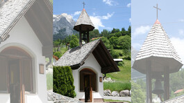 Die malerische Herz-Jesu-Kapelle mit Schindeldach und Kreuz, eingebettet in die grüne Landschaft von Flirsch.