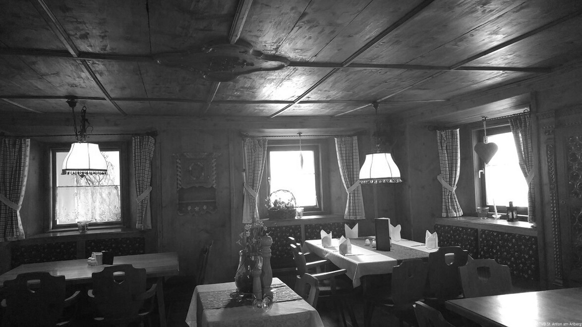 Traditionelle Gaststube mit Holzvertäfelung und gedeckten Tischen / Traditional tavern room with wooden paneling and set tables