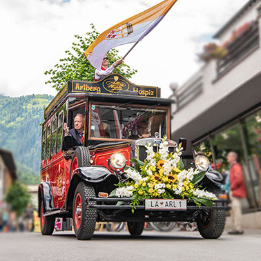 Vintage bus with flower decoration in parade through St. Anton am Arlberg.