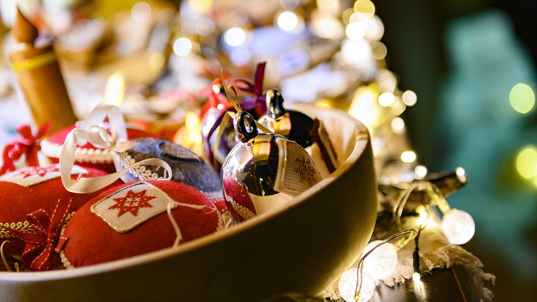 Weihnachtsgeschenke in Schale / Christmas gifts in bowl Nahaufnahme von handgemachten Weihnachtsgeschenken in einer Schale mit Lichterkette / Close-up of handmade Christmas gifts in a bowl with fairy lights