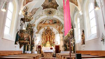 Prunkvoller Altarraum der Schnanner Pfarrkirche mit Fresken und Goldverzierungen – religiöse Kunst und Geschichte.