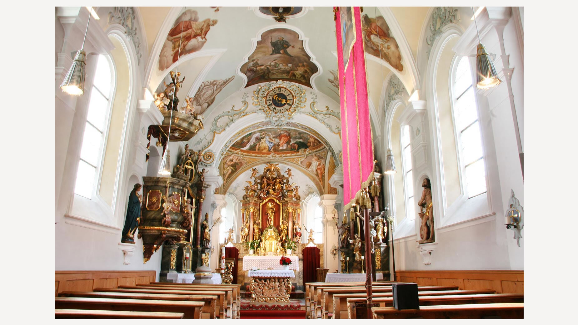 Barocke Kirche mit bemalter Decke, Altar und Dekorationen im Innenraum / Baroque church with painted ceiling, altar, and decorations inside