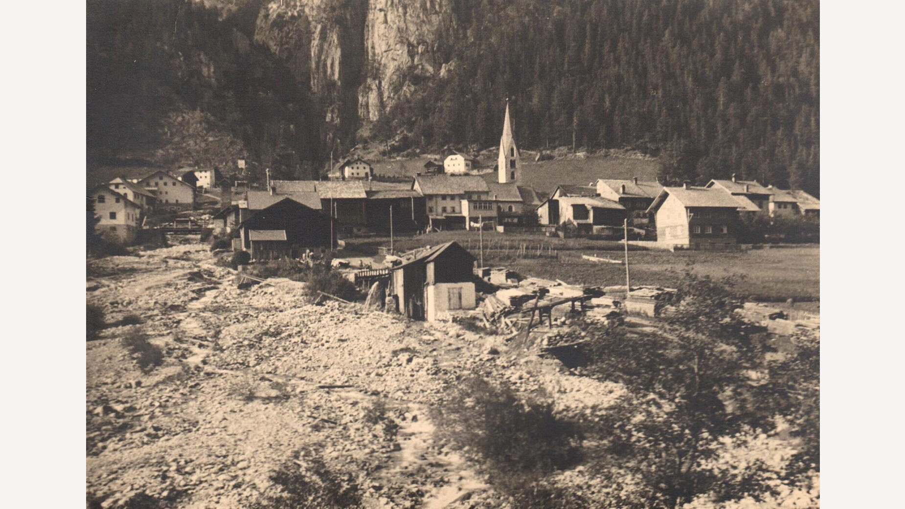 Historisches Dorfbild mit Kirche, Holzhäusern und umliegender Berglandschaft / Historical village scene with church, wooden houses and surrounding mountain landscape