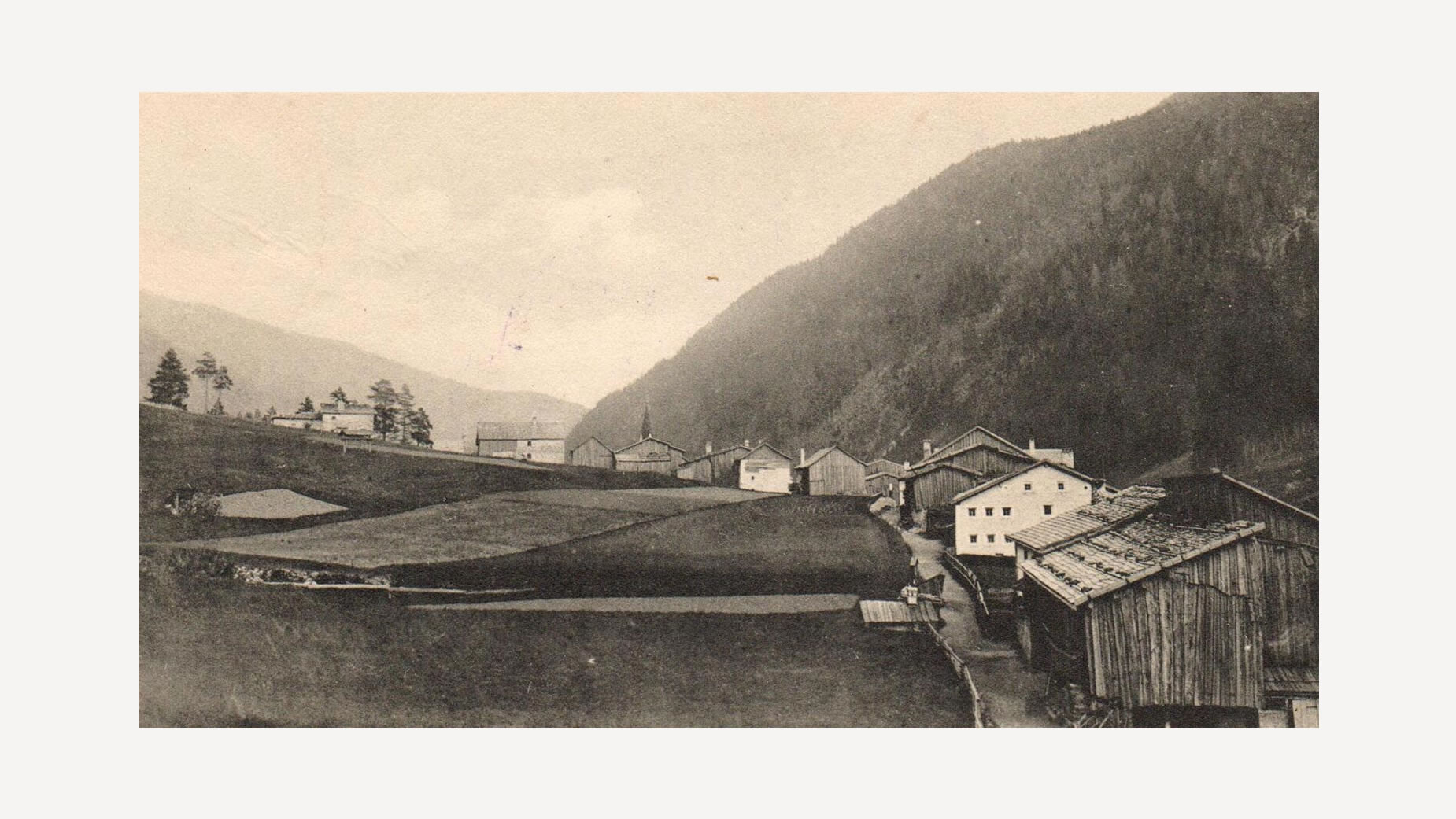 Historische Aufnahme mit Wiesen, Scheunen und einem Gehöft am Talrand bei Schnann / Historic image with meadows, barns and a homestead at the valley edge near Schnann