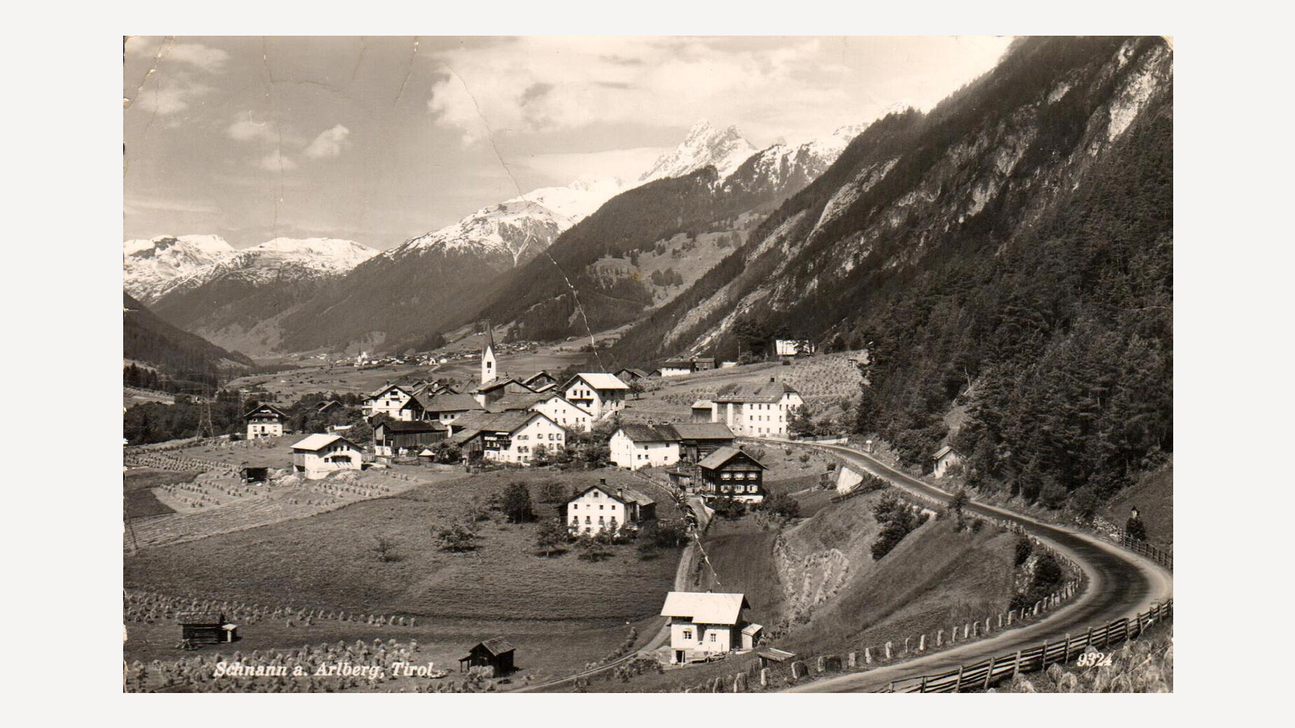 Schnann früher / Schnann in earlier times Historische Panoramaaufnahme von Schnann mit typischer Streusiedlung, umgeben von Bergen, gut sichtbar ist die Pfarrkirche im Ortskern / Historic panoramic view of Schnann with scattered farmsteads, surrounded by mountains, with the parish church visible in the village center