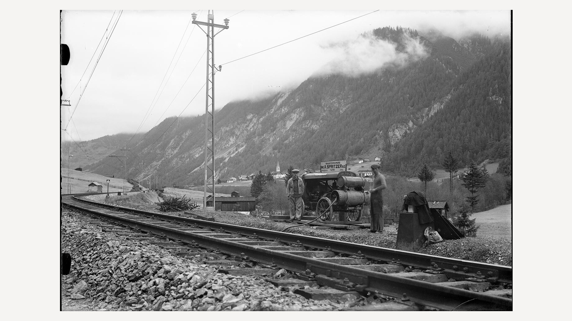 Gleisbau bei Schnann / Track work near Schnann Historische Aufnahme von Gleisarbeiten an der Arlbergbahn bei Schnann, mit Bauwagen und Arbeitern entlang der Schienen / Historic photo of track work on the Arlberg railway near Schnann, showing workers and rail equipment