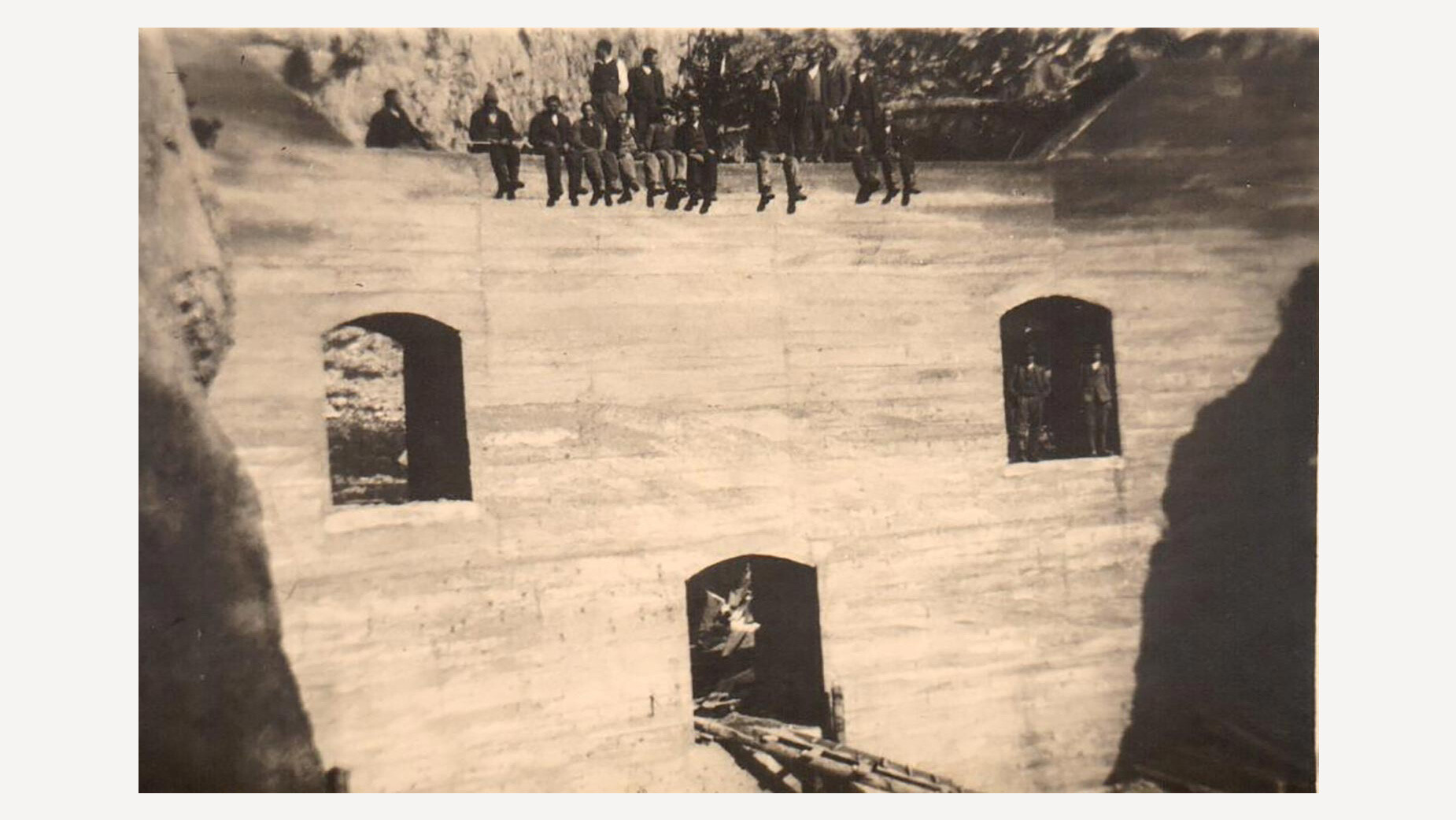 Historisches Foto einer Sperrmauer in der Klamm mit Menschen auf und vor der Mauer / Historic photo of a dam wall in the gorge with people on and in front of the wall