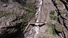 Drohnenaufnahme einer Holzbrücke über das enge Bachbett der Schnanner Klamm / Drone image of a wooden bridge over the narrow stream bed in Schnanner Klamm
