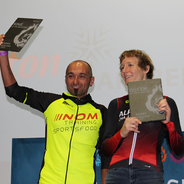 Zwei Sieger halten stolz ihre Trophäen „King“ und „Queen of the Mountain“ beim Arlberg Giro 2021 in die Höhe.